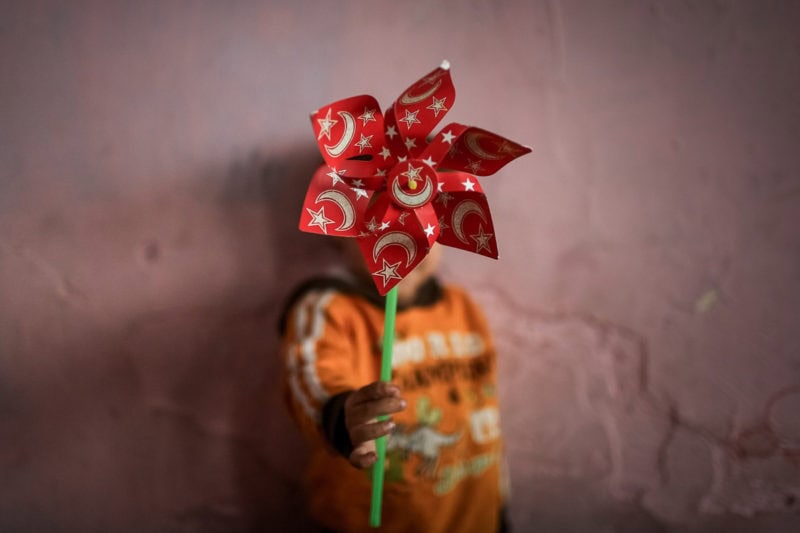 A Syrian Kid Is Playing With A Paper Wheel On Which Turkish Flag